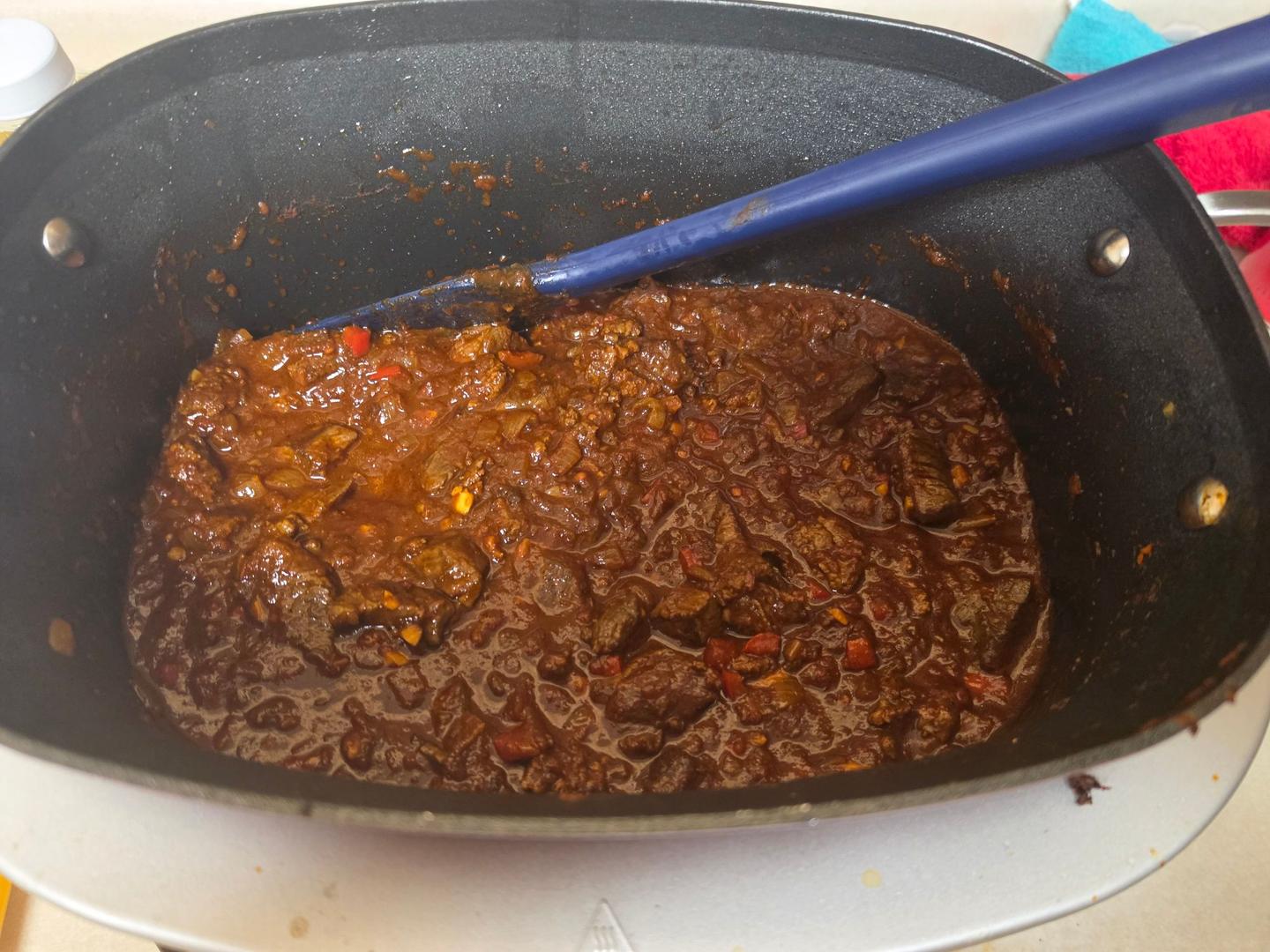 The chili in the multicooker before the beans go in: browned chuck, ground beef and red bell pepper in a thick, dark sauce